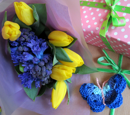 a bouquet of yellow tulips, blue hyacinths and birthday presents