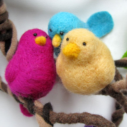 pink, blue and yellow needlefelt birds on a branch