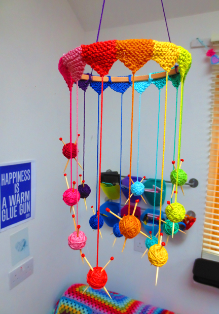 A mobile of mini yarn balls and needles