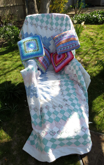 Patchwork Throw, crochet and knitted cushions in garden chair the place to Switch Off